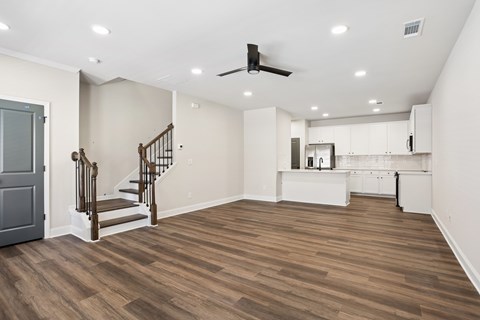 A room with wooden floors and a staircase with a railing.