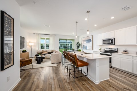 A modern kitchen with white cabinets and a wooden island.