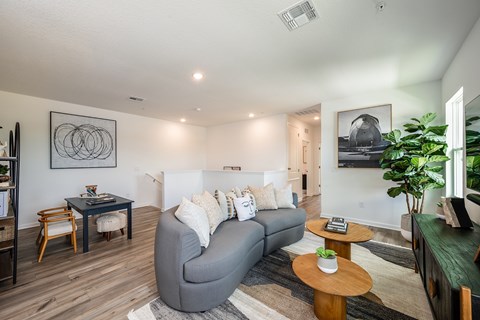 A living room with a grey couch and a wooden coffee table.
