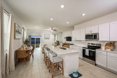 A kitchen with white cabinets and a large island.
