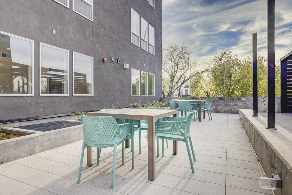 a patio with tables and chairs outside of a building