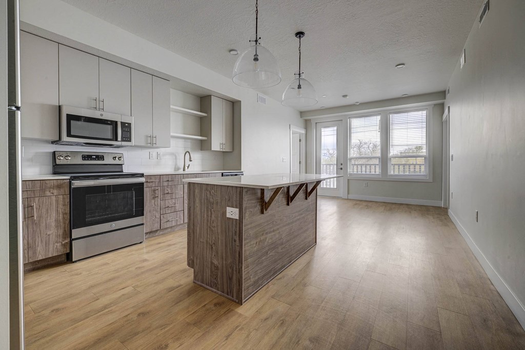 an empty kitchen with a large island in the middle