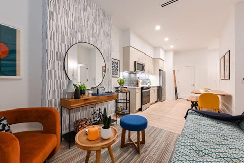 A living room with a red chair and a blue stool.