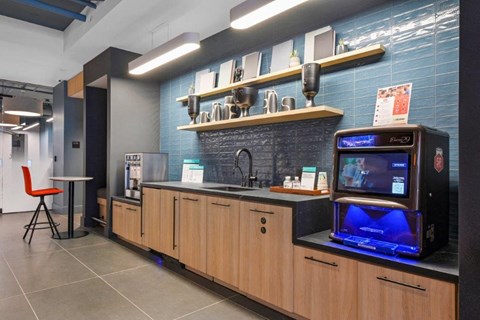 A modern kitchen with wooden cabinets and a blue tiled backsplash.
