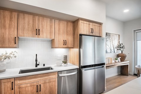 A modern kitchen with wooden cabinets and stainless steel appliances.
