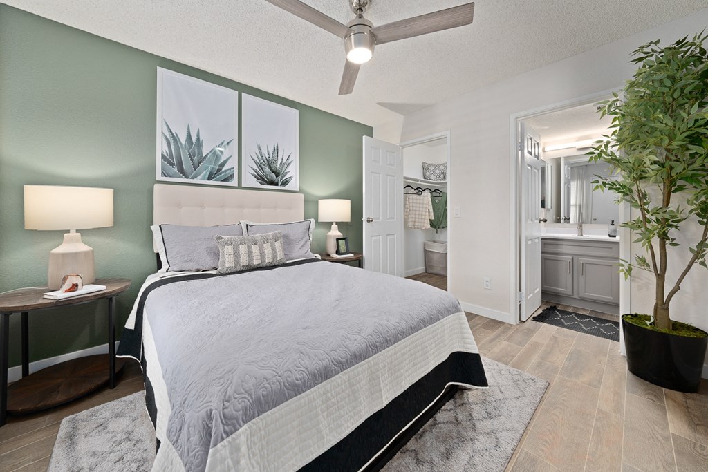 a bedroom with a bed and a bathroom with a plant