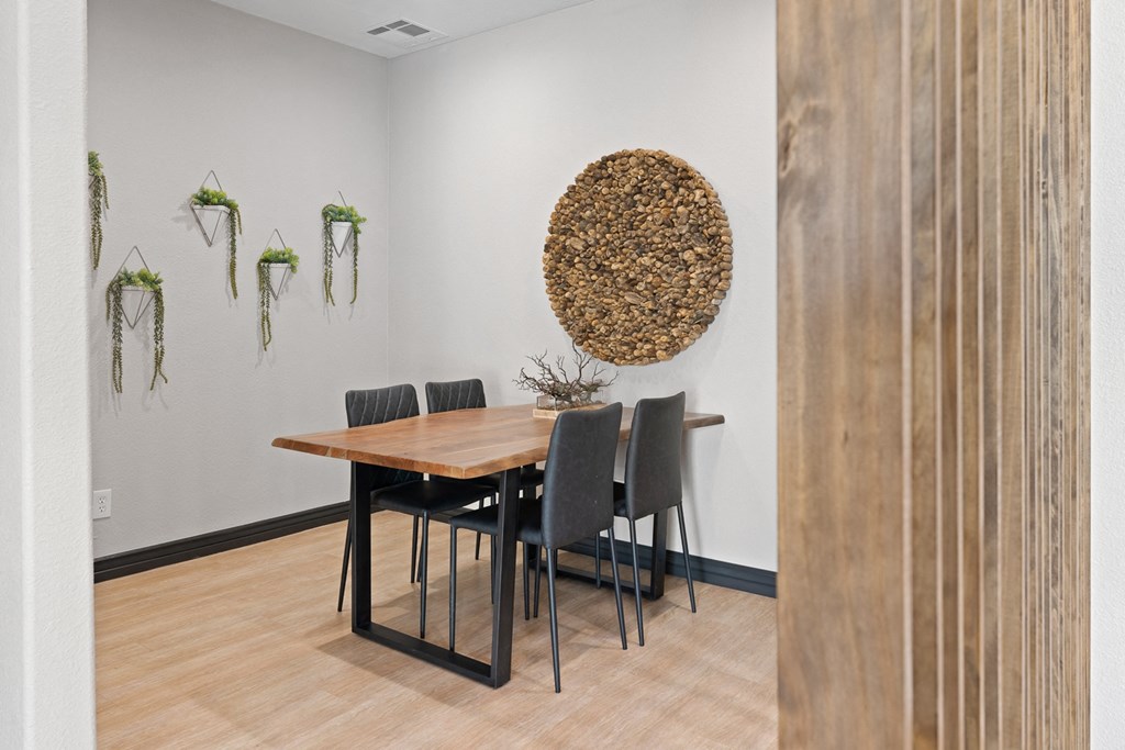 a dining room with a wooden table and black chairs