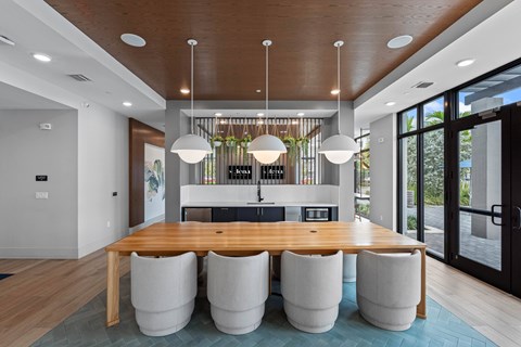 A modern dining room with a wooden table and white chairs.