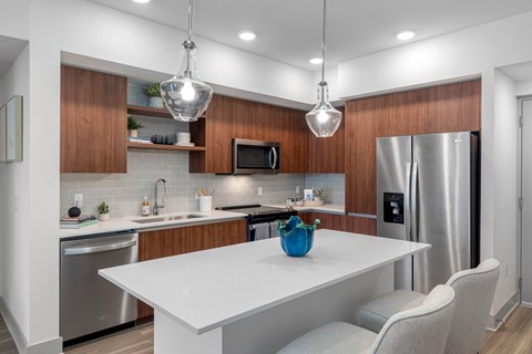 A modern kitchen with a white table and wooden cabinets.