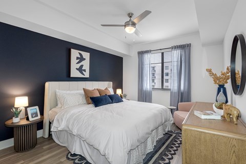 A bedroom with a large bed and a ceiling fan.