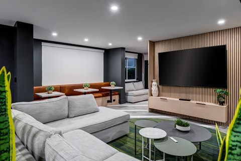 A modern living room with a grey sofa and a black television.