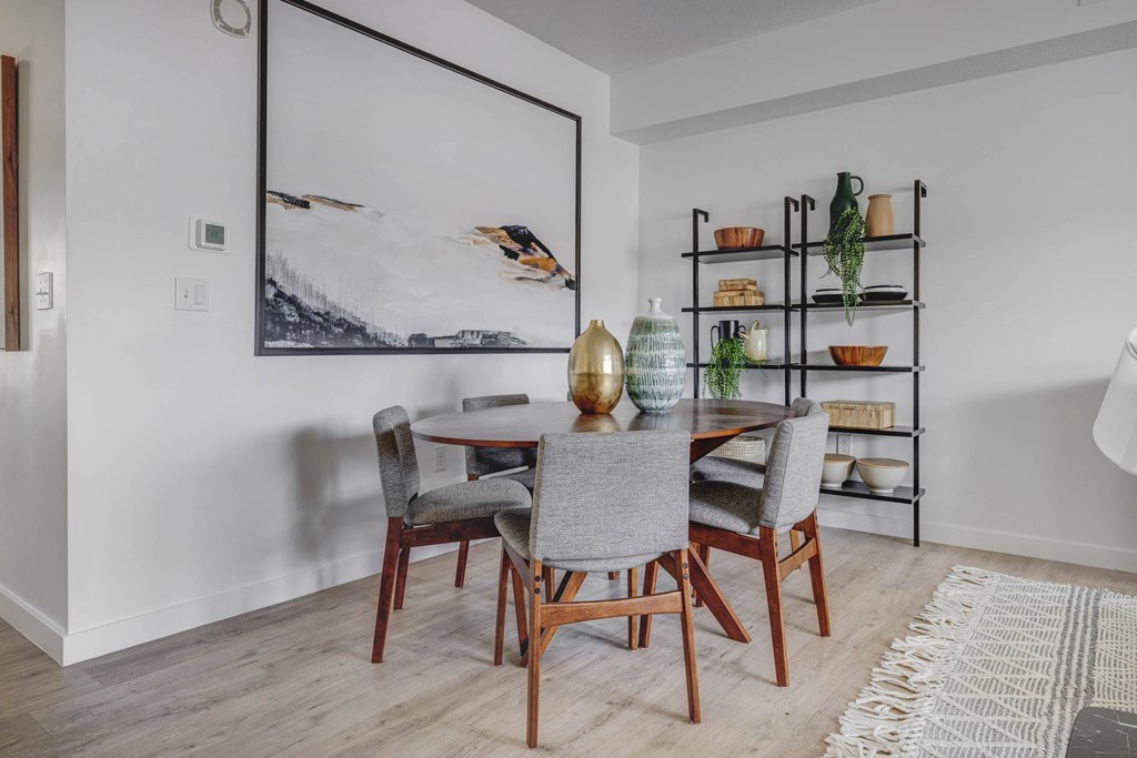 a dining room with a round table and grey chairs