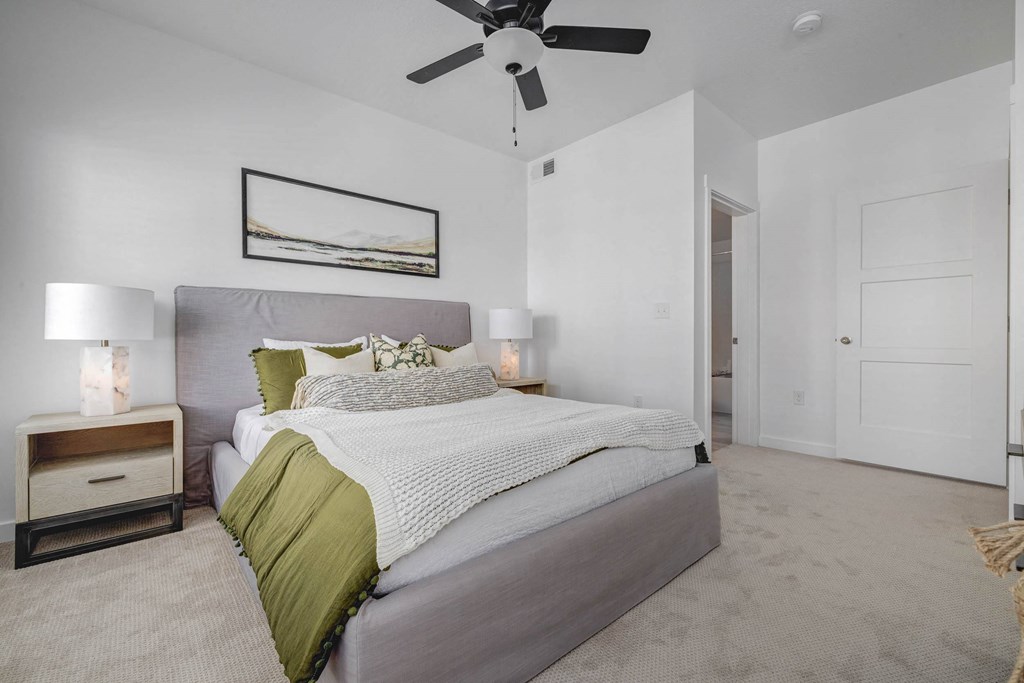 a bedroom with a bed and a ceiling fan