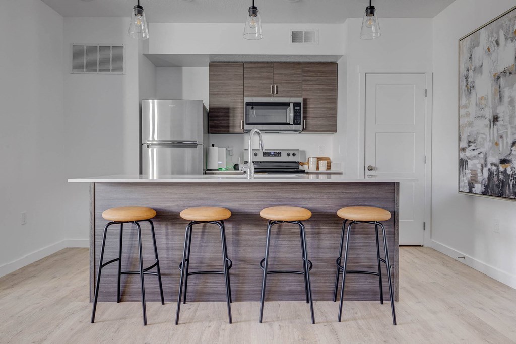 a kitchen with a large island with three stools in front of it