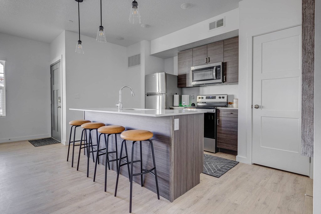 a kitchen with a large island with three stools in front of it