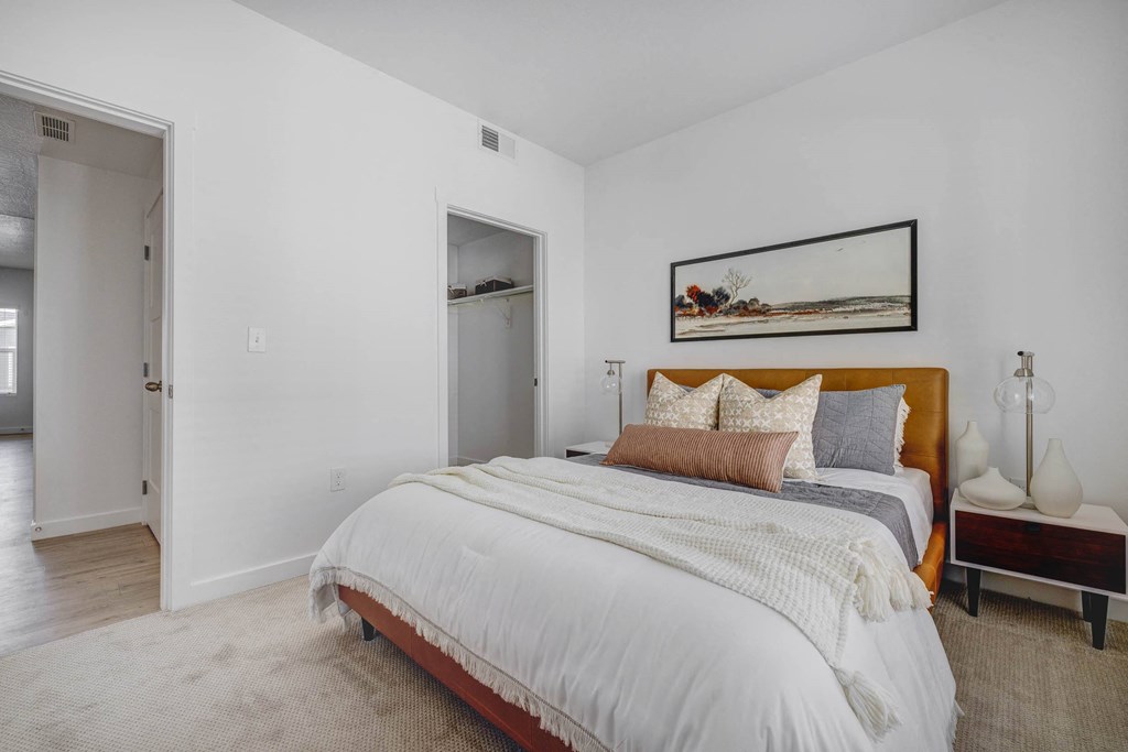 a bedroom with a large bed and a door to a bathroom