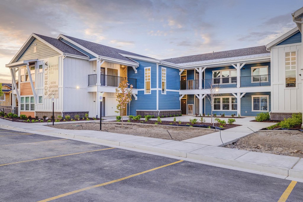 a row of blue and white townhomes with a sidewalk in front of them