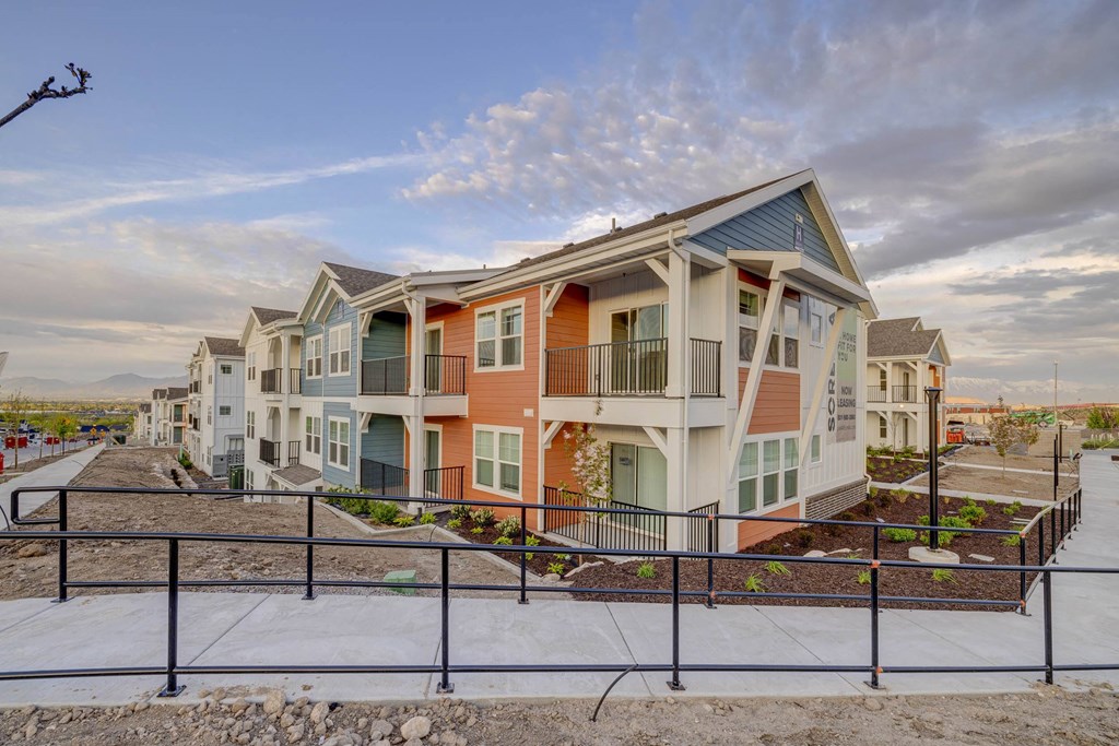 a row of town homes with a sidewalk in front of them