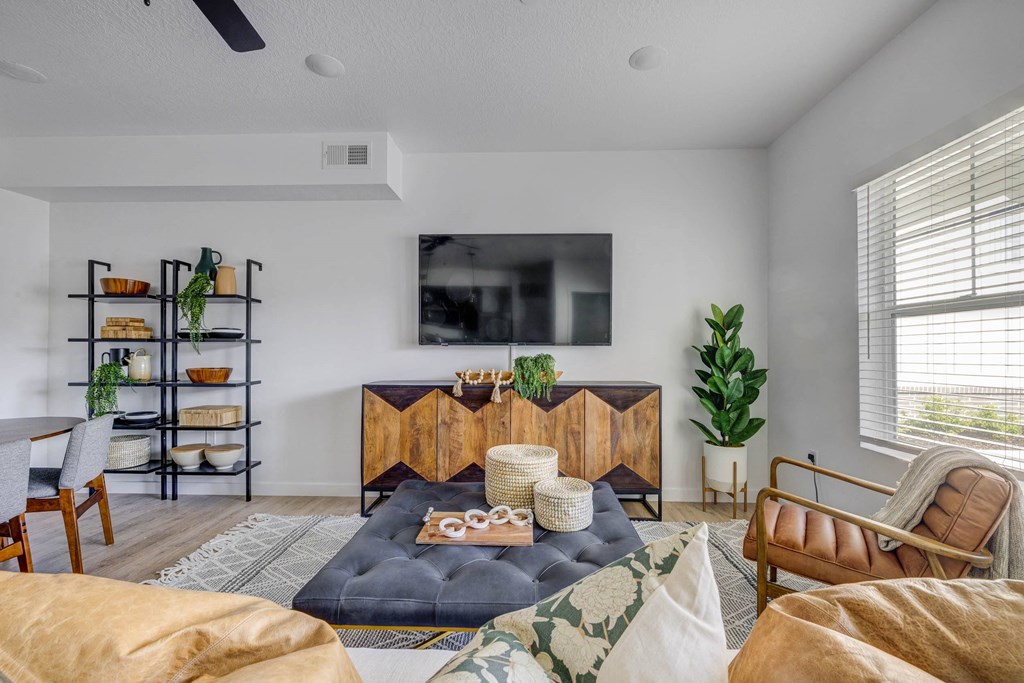 a living room with white walls and a tv on the wall