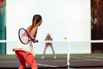 two women playing tennis on a tennis court