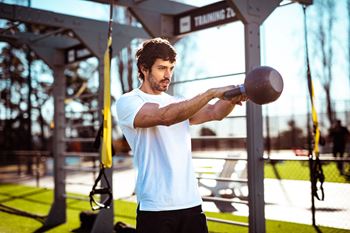 a man holding a medicine ball in a gym