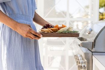 a woman holding a plate of food in a kitchen