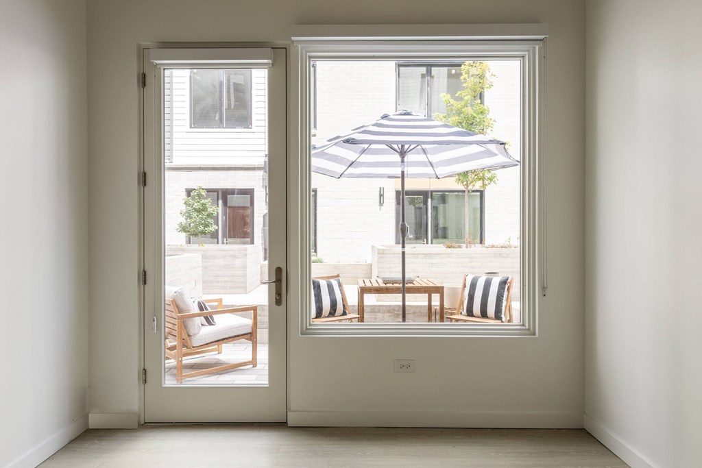 A patio with a table and chairs is visible through a sliding glass door.