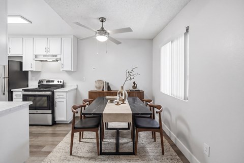 A modern kitchen with a dining table set for four.