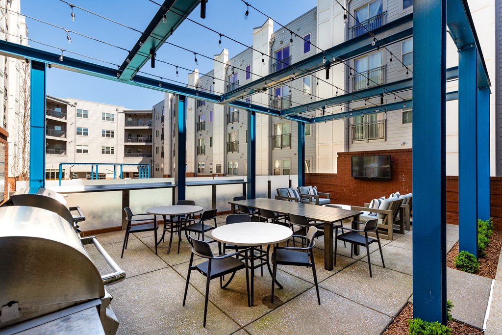a patio with tables and chairs outside of a building