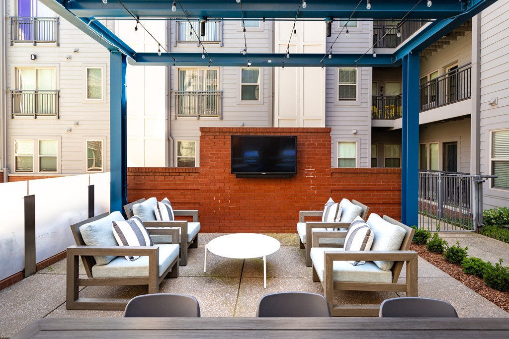 a lounge area with chairs and a table and a television