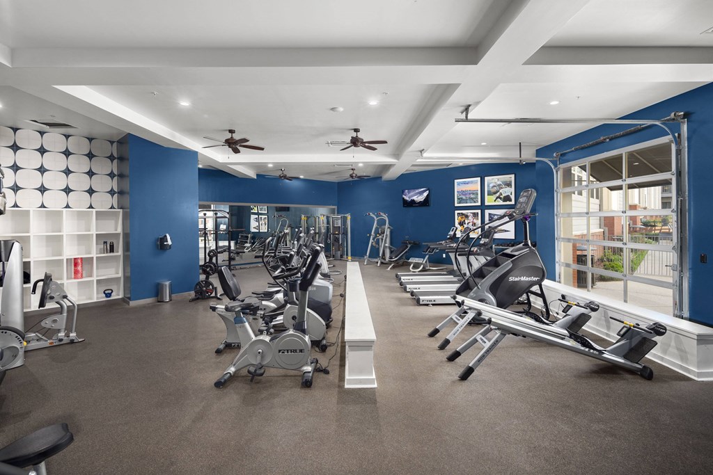 a gym with treadmills and other exercise equipment in a building with blue walls
