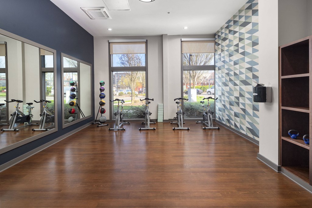 a fitness room with exercise equipment and windows