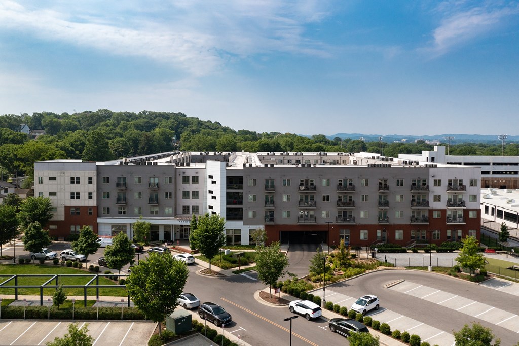 an aerial view of a large building with cars parked in a parking lot
