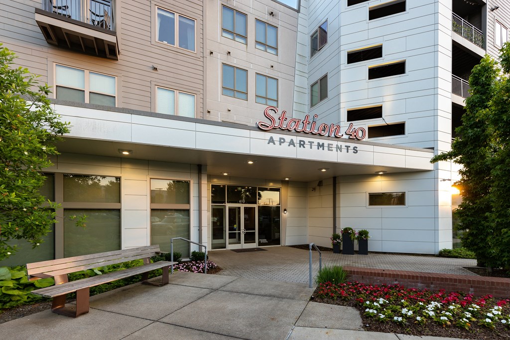 a building with a sidewalk and a bench in front of it