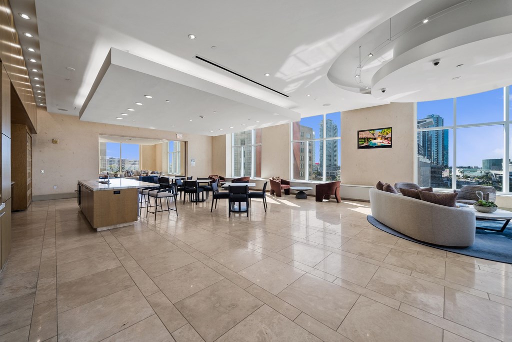 A spacious living room with a large window overlooking the city.