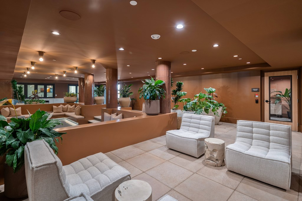 A spacious room with white chairs and a round table.