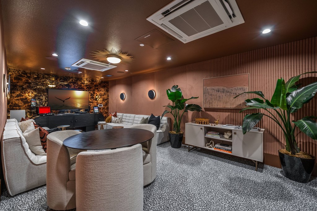 A living room with a black table and white chairs.
