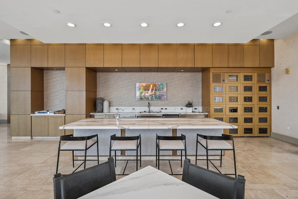 A kitchen with a dining table and chairs in the foreground.