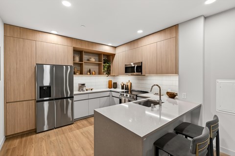A modern kitchen with a stainless steel refrigerator and a white countertop.