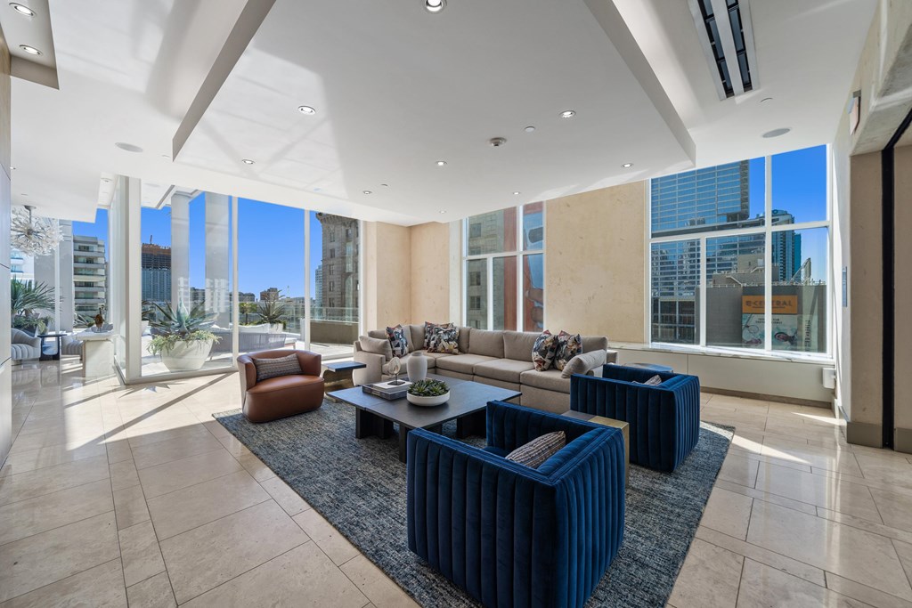 A spacious living room with a large window overlooking the city.