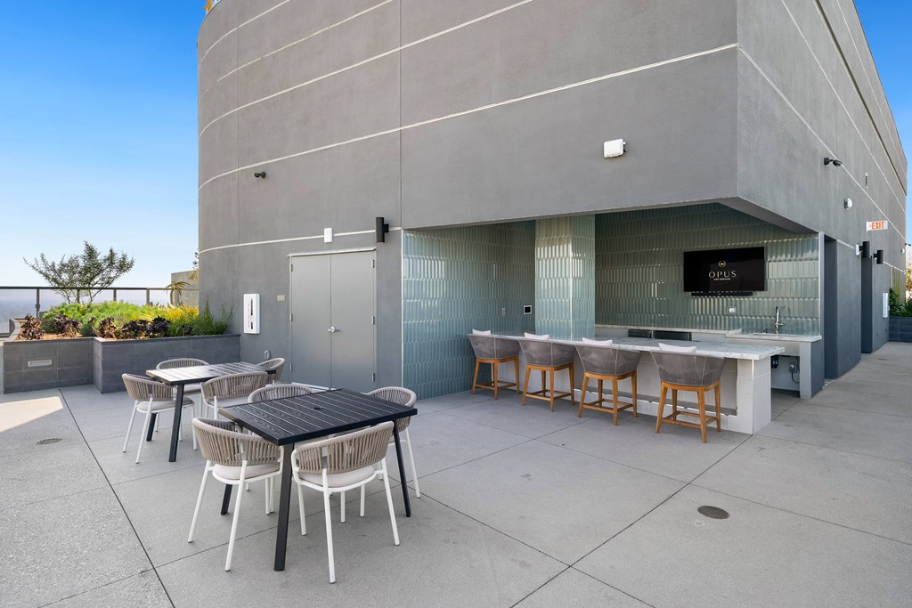 the patio of the building has tables and chairs and a bar