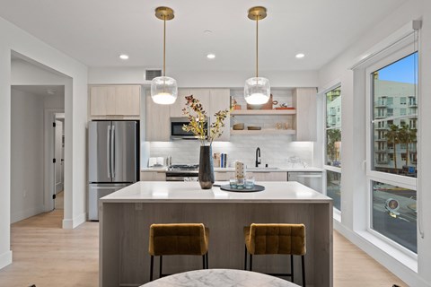 a kitchen with a large island with two chairs and a table