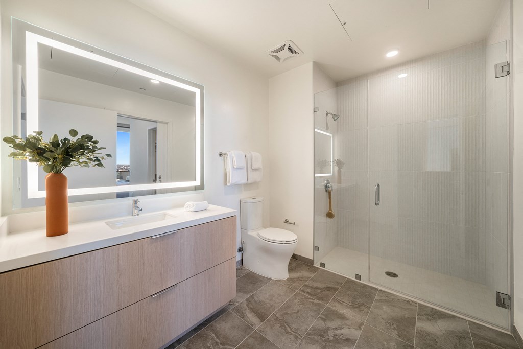 a bathroom with a large mirror and a shower