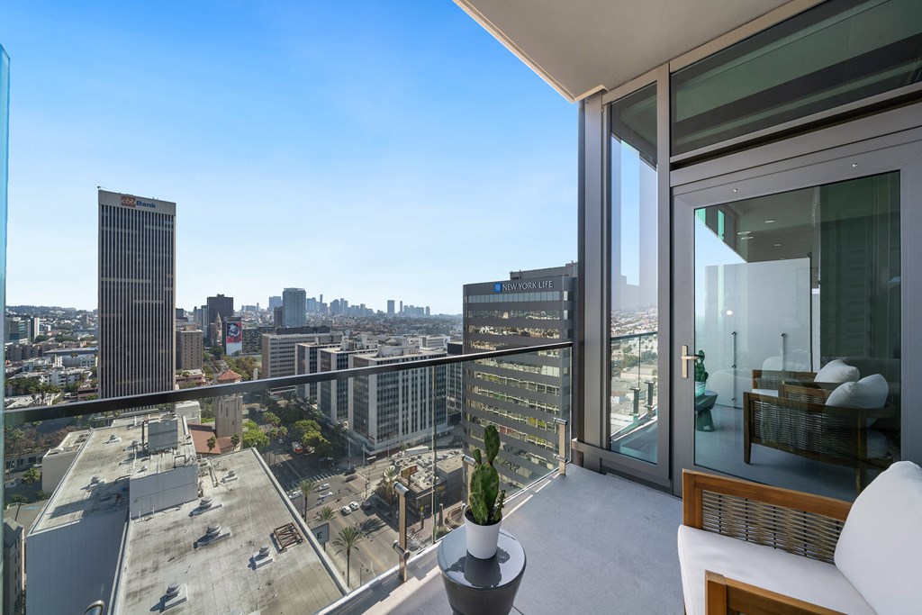 a balcony with a view of the city and a white couch