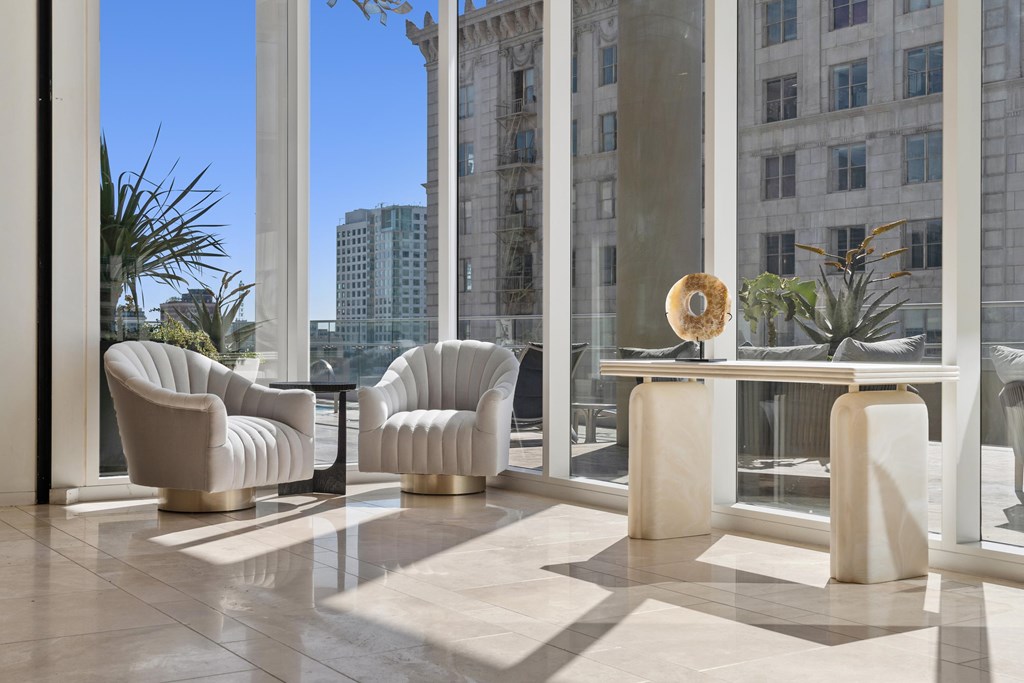 A room with a table and chairs with a view of a building outside.