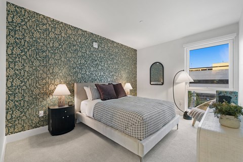 a bedroom with a bed and a wall with a green wallpaper
