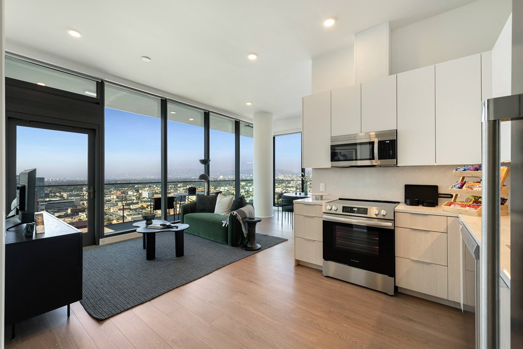 a living room with a kitchen and a view of the city