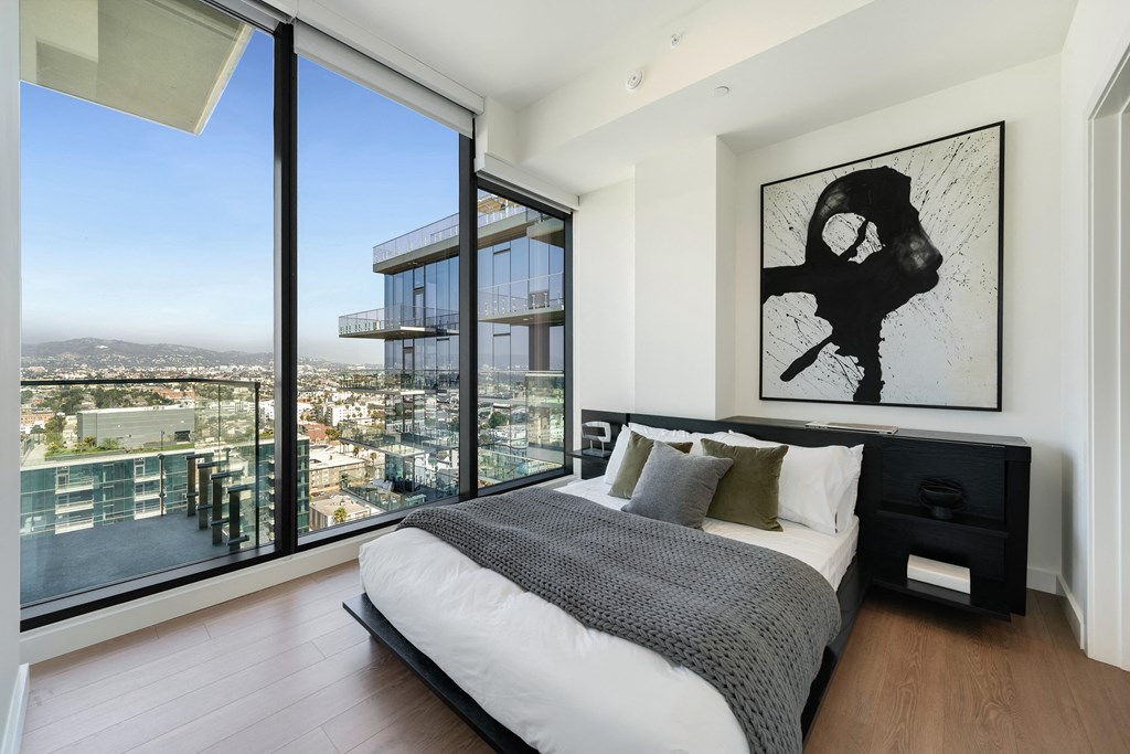 a bedroom with a bed and a view of the city