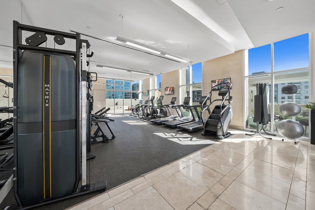 A gym with a variety of equipment including treadmills, weights, and exercise machines.