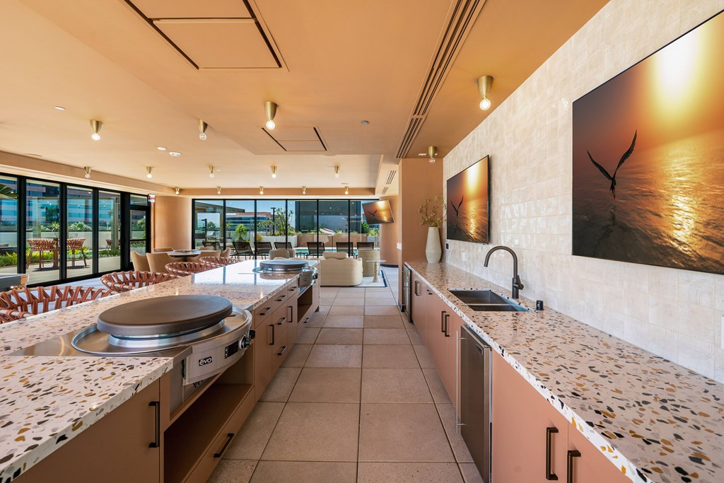 A kitchen with a long counter and a painting on the wall.